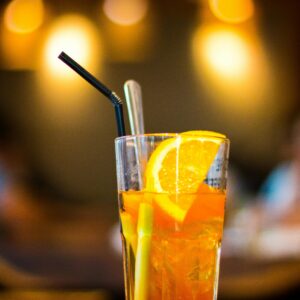 A vibrant orange iced tea garnished with fresh citrus slices in a lively indoor setting.
