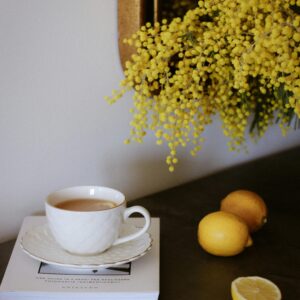 Elegant tea setting with lemons and mimosa flowers on a table for a warm and inviting atmosphere.
